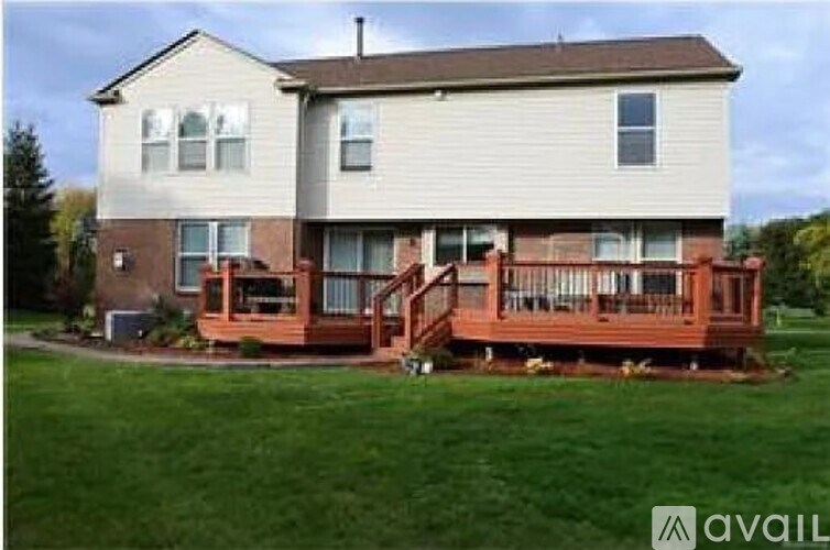 A two-story house with a deck in the front yard.