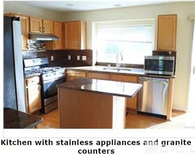 A kitchen with stainless steel appliances and granite counters.