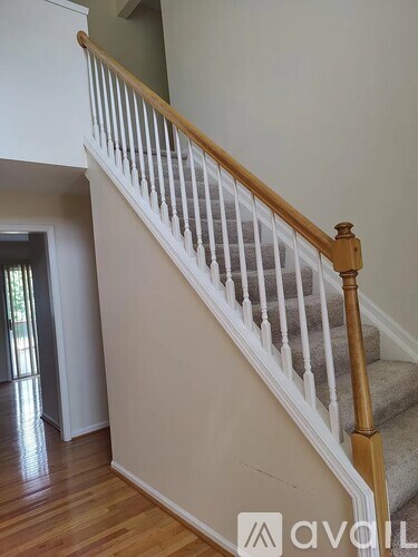A wooden staircase with white railings.