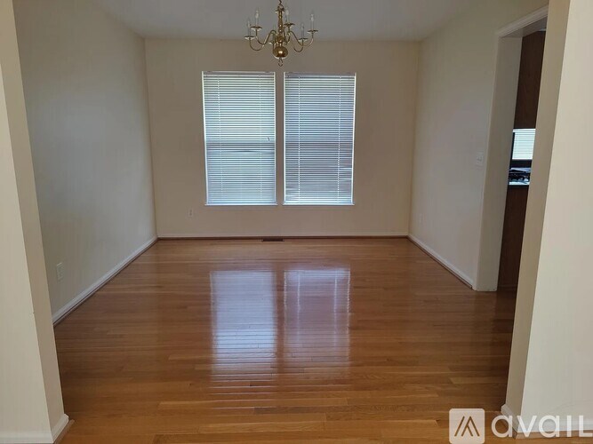 A room with wooden floors and a chandelier.