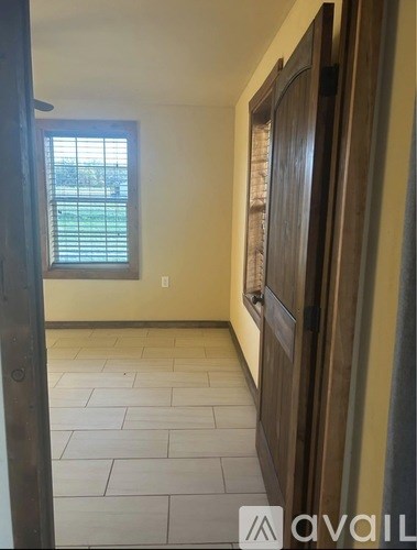 A room with a window and a tiled floor.