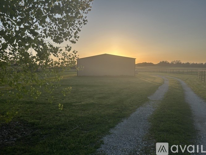A barn is seen in the distance with a path leading to it.