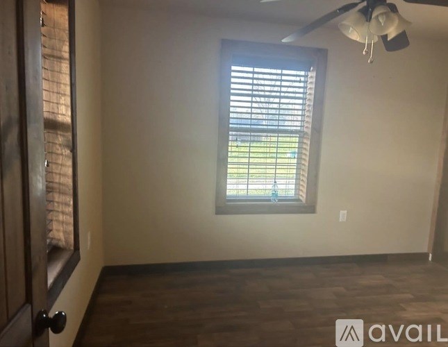 A room with a window and a ceiling fan.