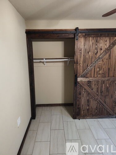 A room with a wooden door and a white wall.