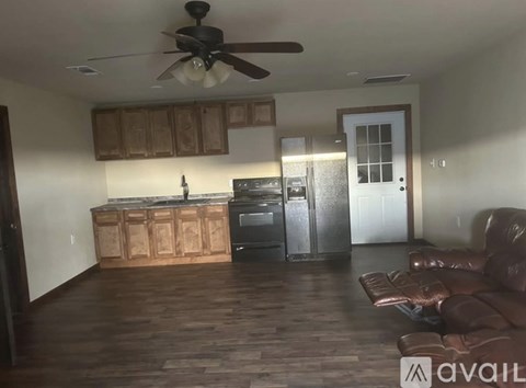 A kitchen with wooden cabinets and a refrigerator.