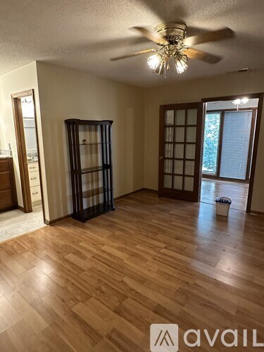 A room with wooden floors and a ceiling fan.