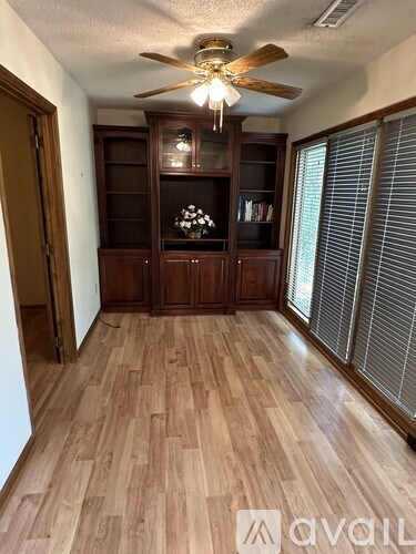 A room with wooden flooring and a ceiling fan.