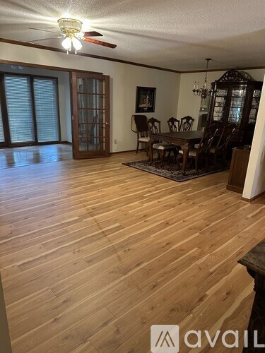 A room with wooden flooring and furniture.