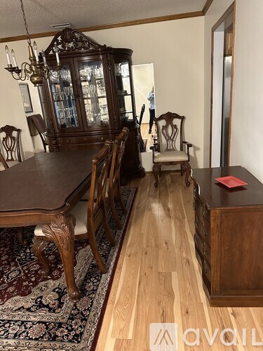 A room with a wooden table and chairs and a china cabinet.