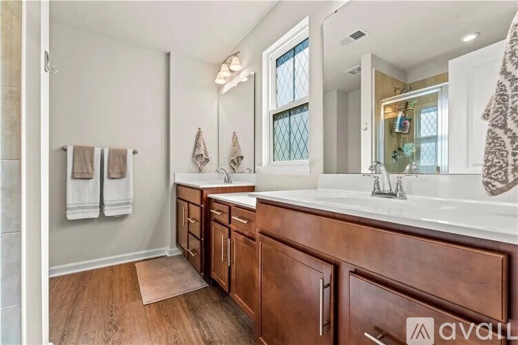 A bathroom with a wooden vanity and a large mirror.