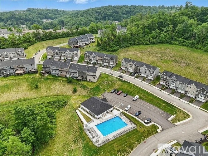A bird's eye view of a residential area with houses, a swimming pool, and a parking lot.