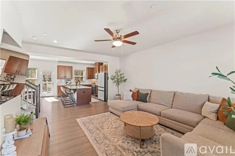 A living room with a beige couch and a round wooden coffee table.