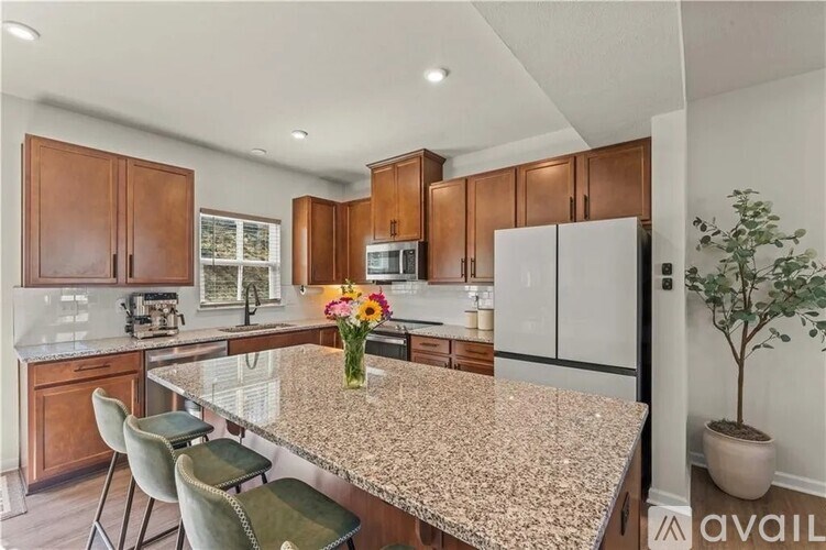 A kitchen with granite countertops and wooden cabinets.