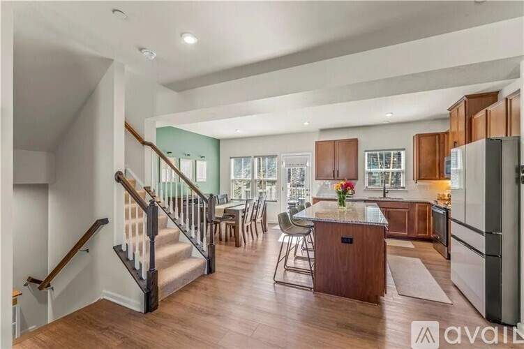 A spacious kitchen and dining area with wooden floors and a staircase.