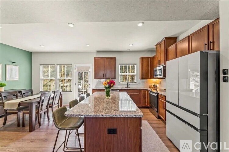 A kitchen with a granite countertop and a refrigerator.