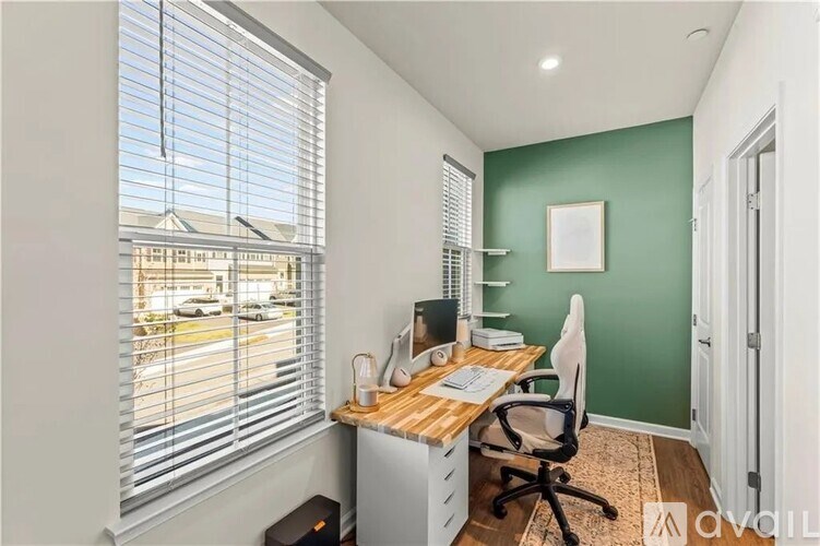 A room with a desk, chair, and window with blinds.