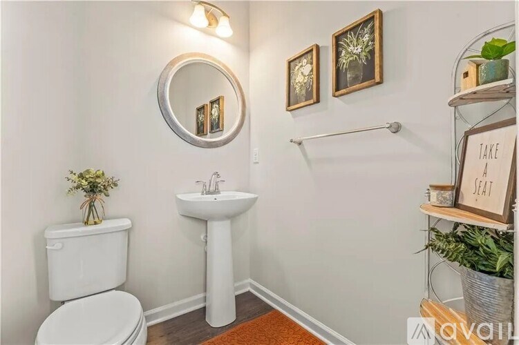 A bathroom with a toilet, sink, and a mirror.