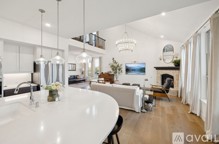A modern kitchen with a white countertop and a dining area with a table and chairs.