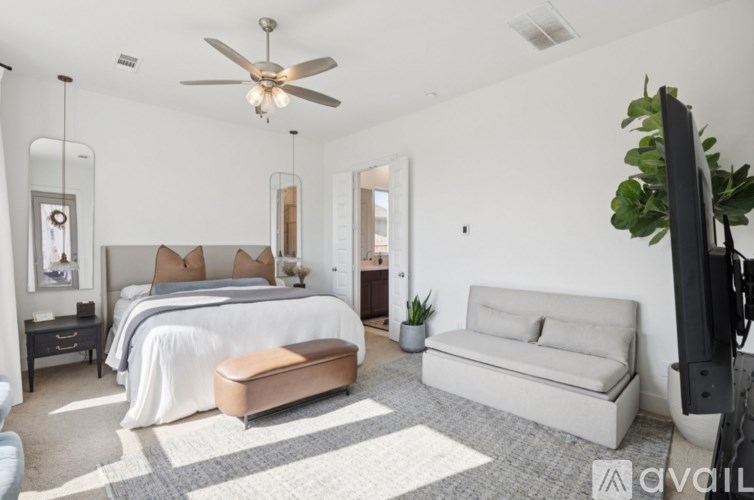A modern bedroom with a large bed and a flat-screen TV.