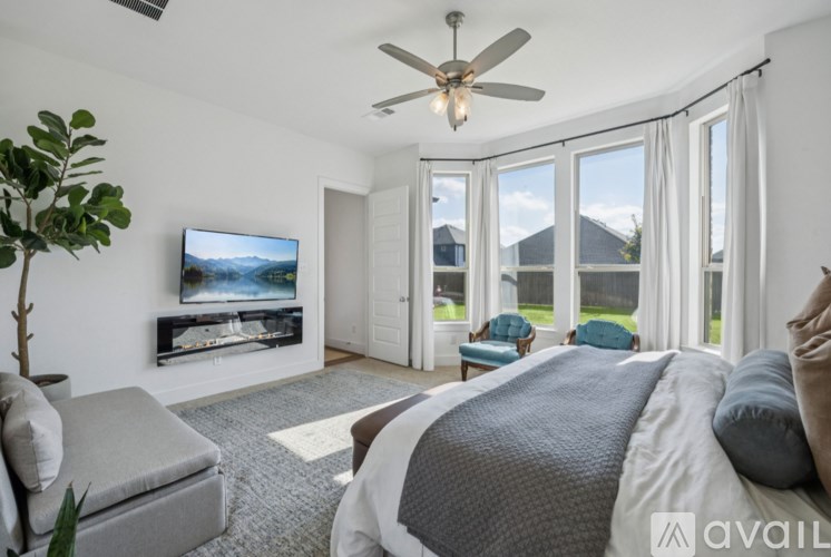 A bedroom with a large bed and a television in the corner.