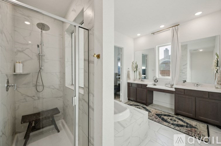 A modern bathroom with a walk-in shower and double sinks.
