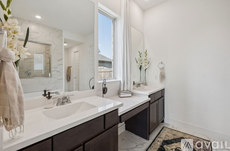 A bathroom with a white sink and a mirror.