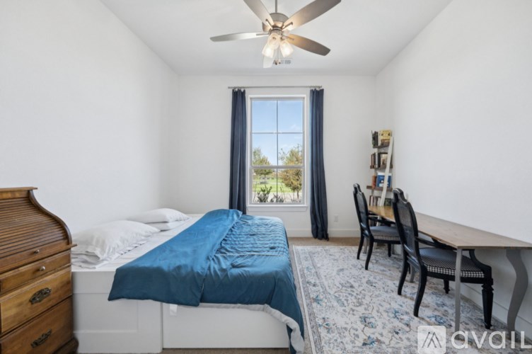 A bedroom with a bed, desk, and chair.