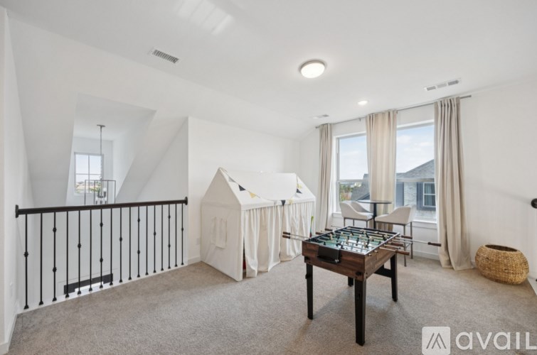 A room with a table, chairs, and a dollhouse.