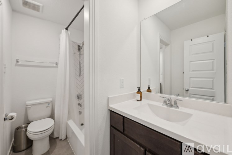 A bathroom with a toilet, sink, and shower.