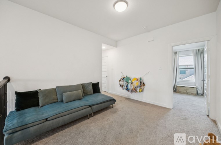A living room with a blue couch and a wall hanging.