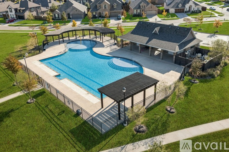 A large outdoor swimming pool with a deck and a pavilion.