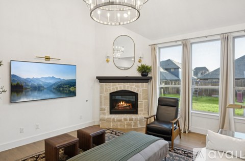 A living room with a fireplace and a painting of a mountain landscape on the wall.