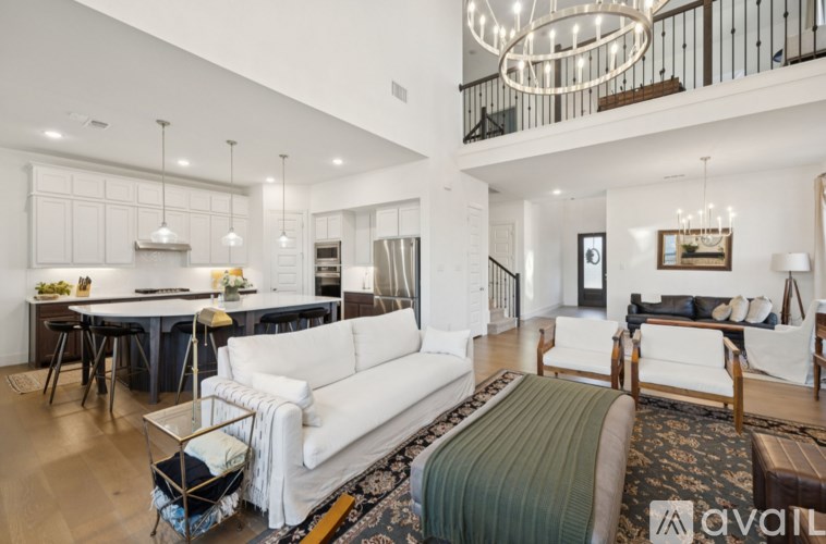 A modern living room with a white sofa and a chandelier.