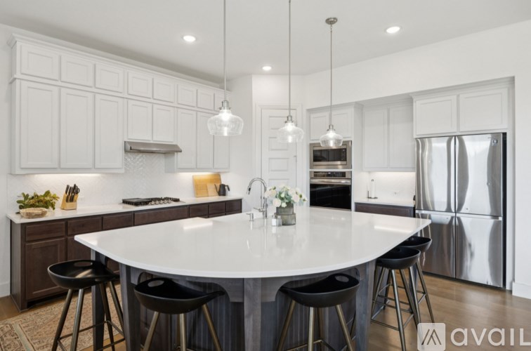 A modern kitchen with a large island and stools.