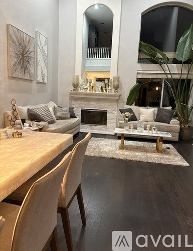 A modern living room with a fireplace and a dining table set for two.