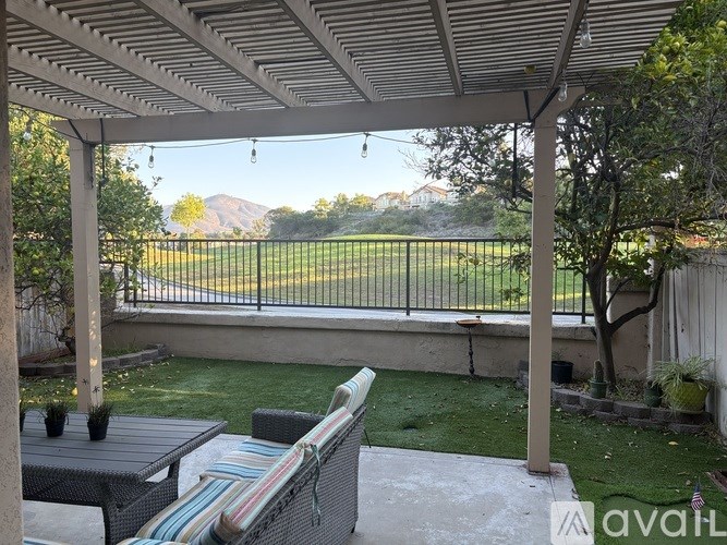 A patio with a striped couch and a table under a roof.