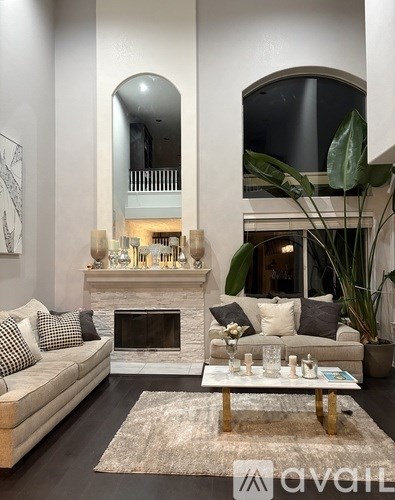 A living room with a couch, coffee table, and a fireplace.
