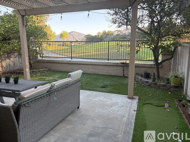 A patio with a wicker chair and a table.