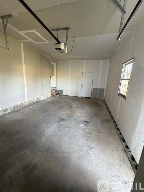 A large empty room with a concrete floor and white walls.