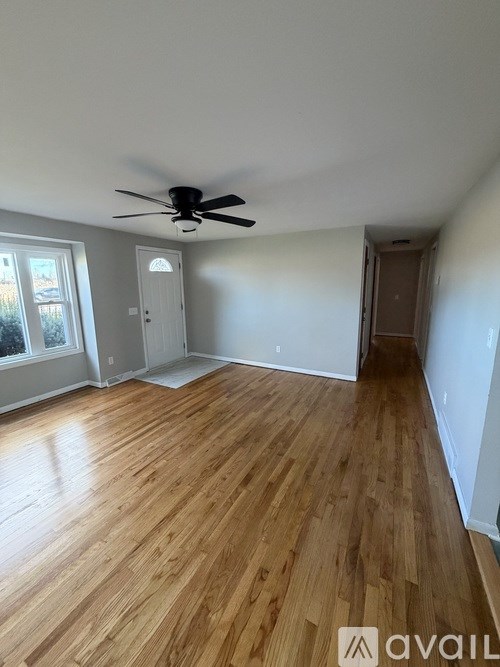 A room with wooden flooring and a ceiling fan.