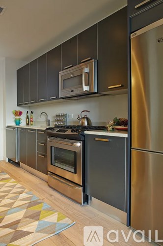 A kitchen with a black countertop and stainless steel appliances.