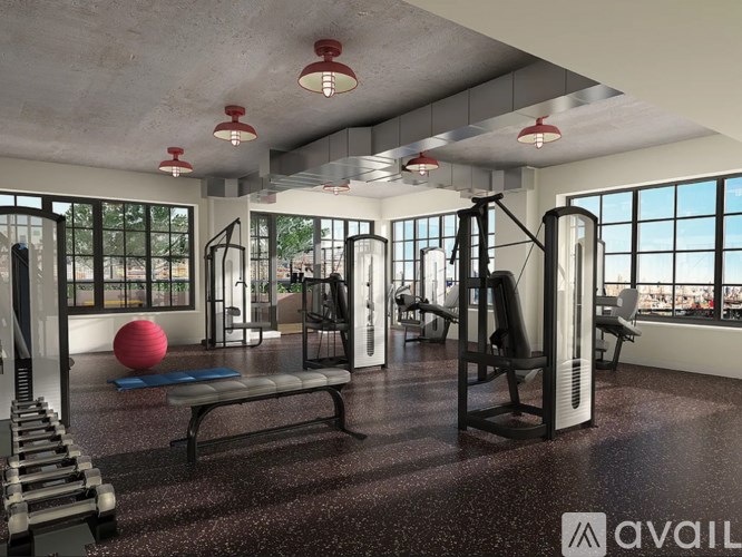 A gym with a variety of equipment including a bench, weights, and a ball.