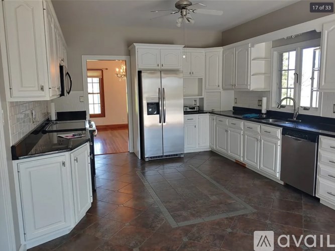 A kitchen with white cabinets and a black countertop.