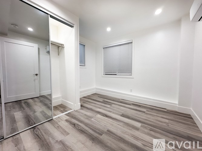 A room with a wooden floor and a white door.