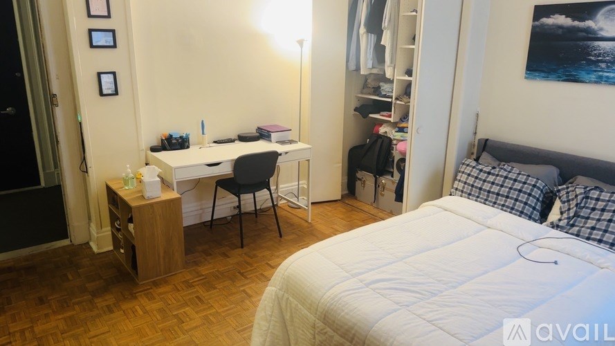 A bedroom with a bed, desk, and chair.