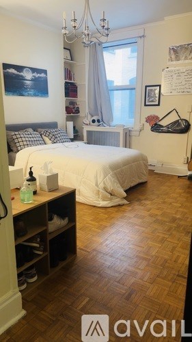 A bedroom with a large bed and a chandelier.