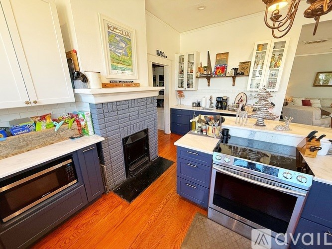 A kitchen with a fireplace and a fridge on the wall.