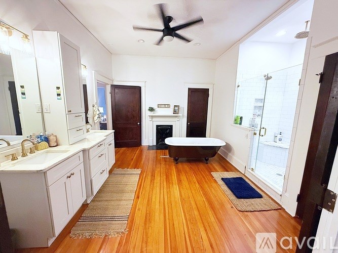 A room with wooden floors and white cabinets.