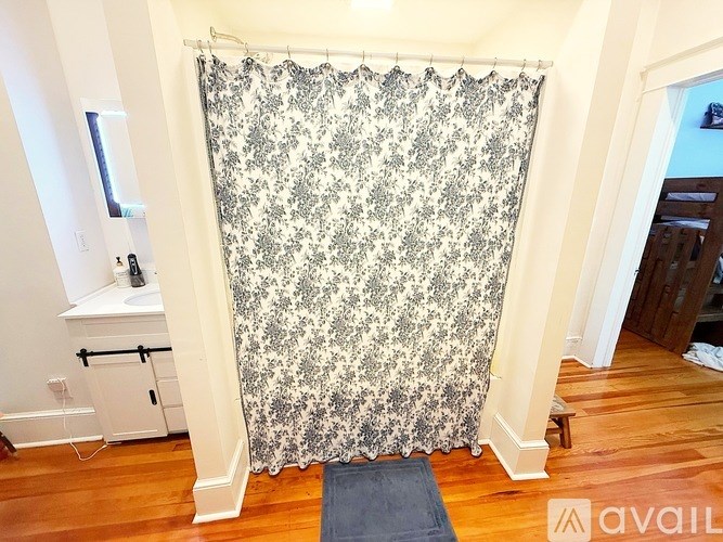 A shower curtain with a black and white pattern hangs in a bathroom.