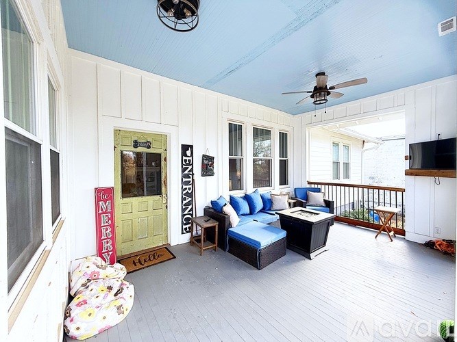 A sunroom with a blue couch and a ceiling fan.